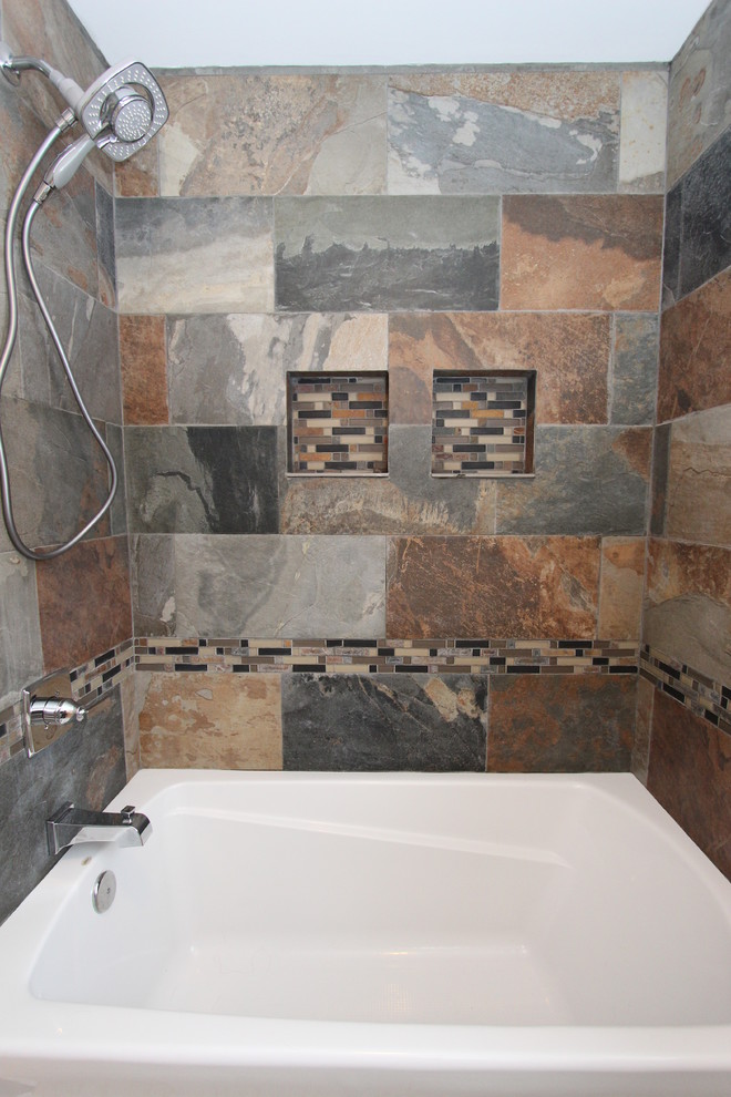 Mid-sized transitional master multicolored tile and porcelain tile porcelain tile alcove bathtub photo in Grand Rapids with an integrated sink, raised-panel cabinets, white cabinets, solid surface countertops, a two-piece toilet and gray walls