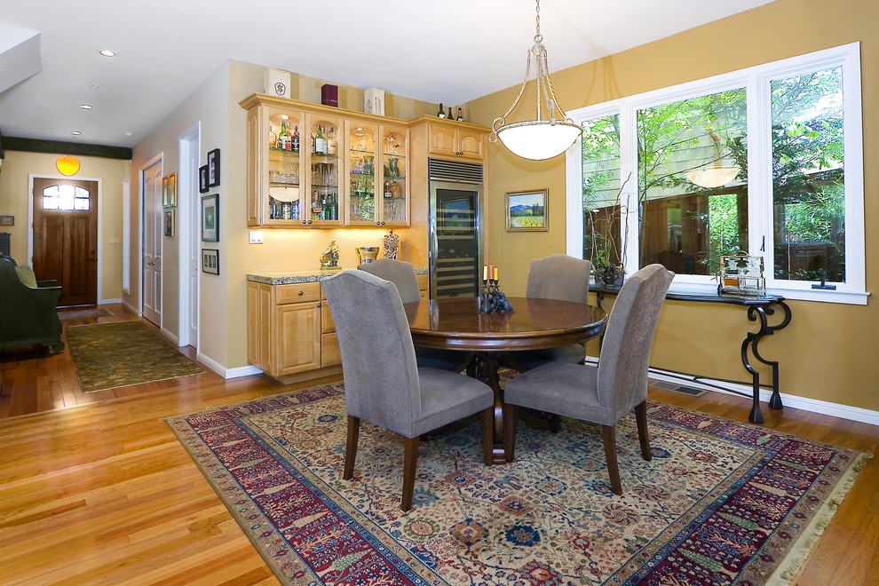 Photo of a traditional dining room in San Francisco with yellow walls and medium hardwood floors.