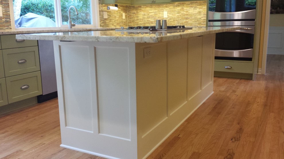 Example of a large transitional u-shaped medium tone wood floor kitchen design in Seattle with a double-bowl sink, recessed-panel cabinets, white cabinets, granite countertops, multicolored backsplash, mosaic tile backsplash, stainless steel appliances and an island
