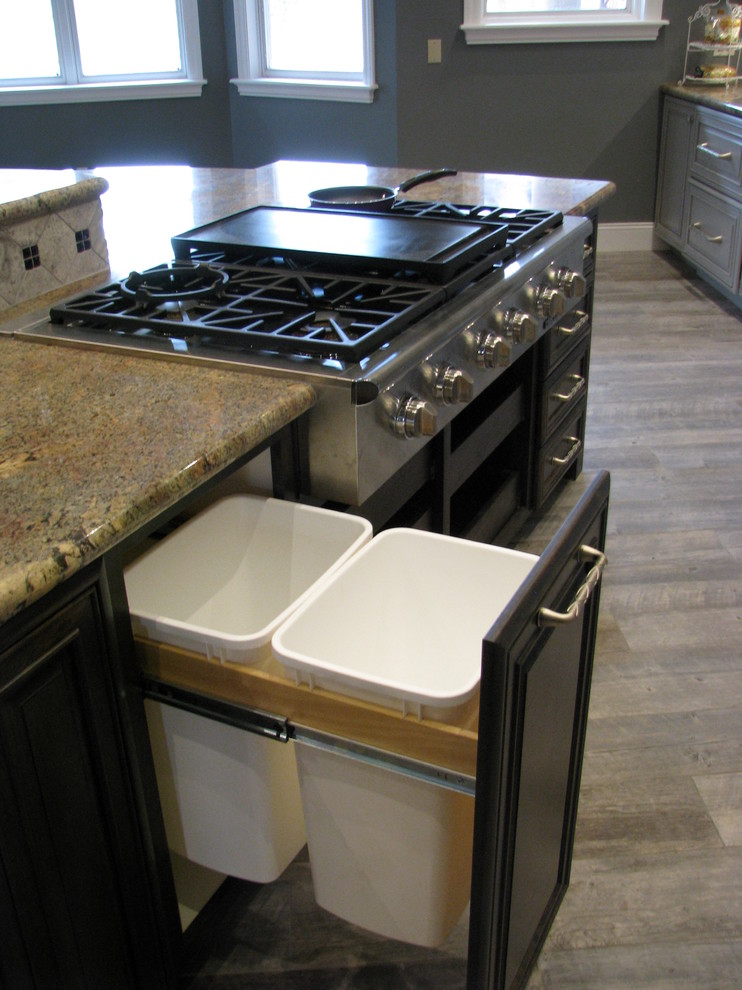 Example of a huge transitional l-shaped porcelain tile open concept kitchen design in Phoenix with an undermount sink, raised-panel cabinets, gray cabinets, granite countertops, gray backsplash, stone tile backsplash, stainless steel appliances and an island