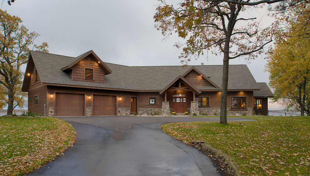 This is an example of a large country one-storey brown exterior in Minneapolis with wood siding and a gable roof.
