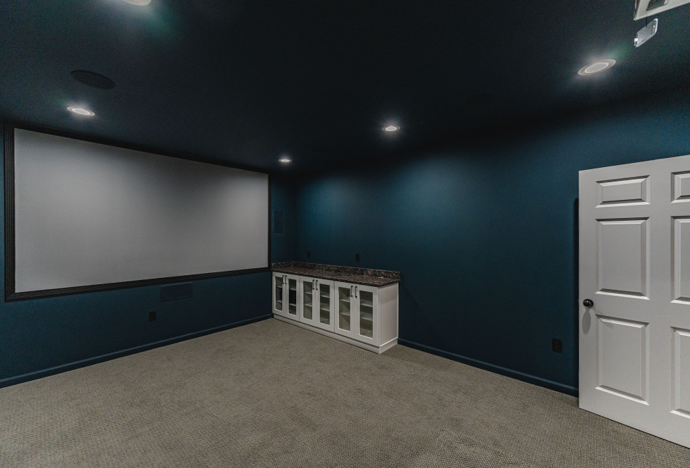 Пример оригинального дизайна: большой подвал в стиле модернизм с домашним кинотеатром, бежевыми стенами, темным паркетным полом, коричневым полом, многоуровневым потолком и кирпичными стенами без камина