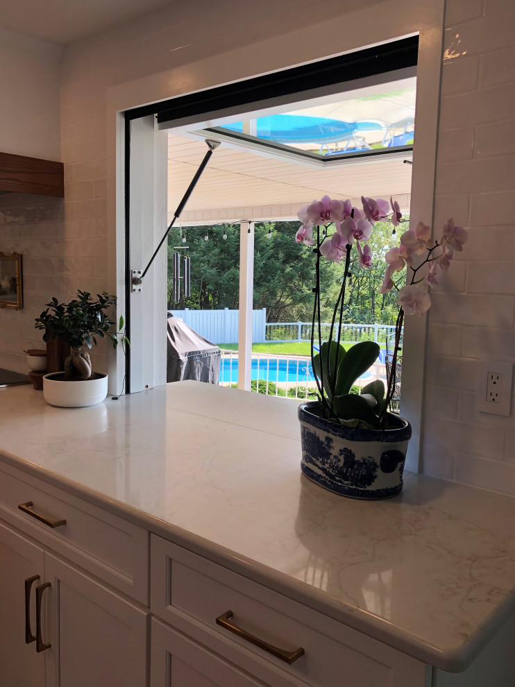 Inspiration for a mid-sized transitional l-shaped medium tone wood floor and brown floor kitchen pantry remodel with an undermount sink, flat-panel cabinets, blue cabinets, quartz countertops, white backsplash, subway tile backsplash, stainless steel appliances, an island and gray countertops