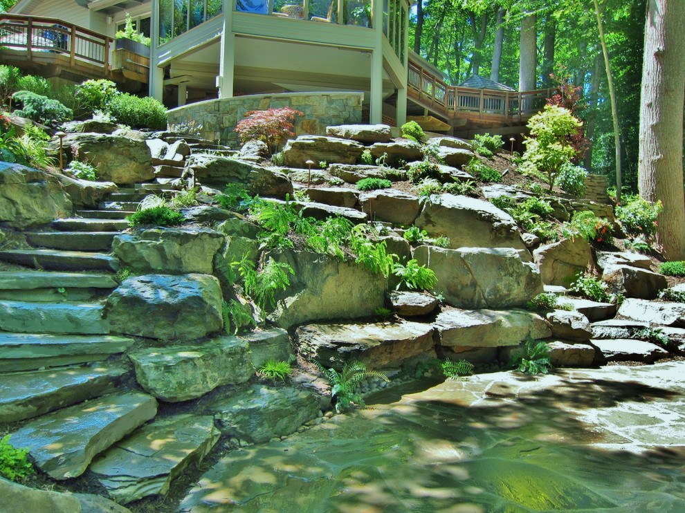 Inspiration for a large country sloped shaded xeriscape in DC Metro with a retaining wall and natural stone pavers.