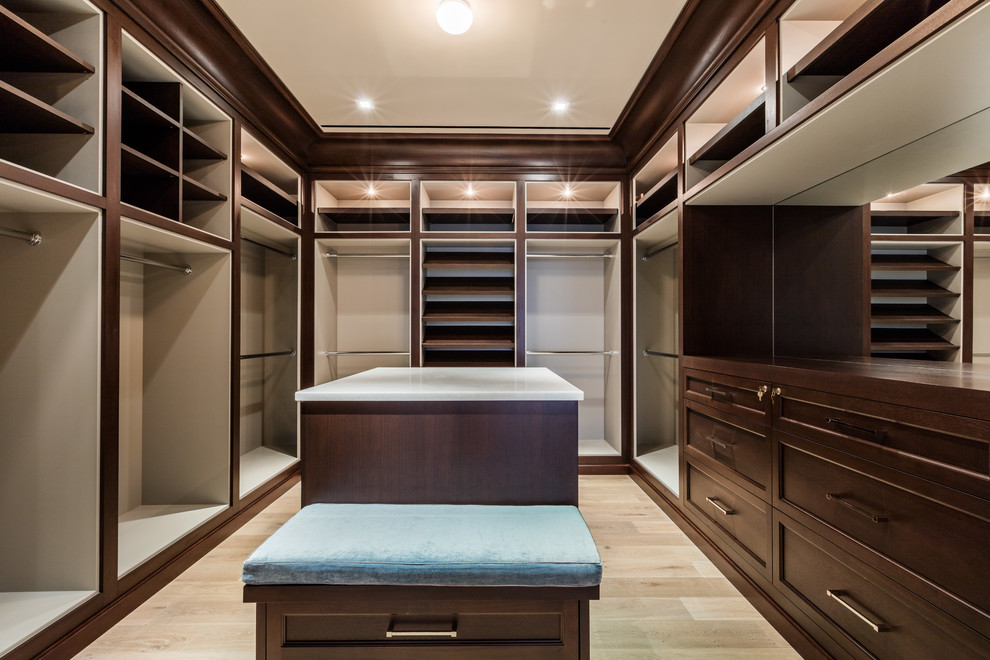 This is an example of an expansive transitional gender-neutral dressing room in Miami with medium wood cabinets, light hardwood floors and recessed-panel cabinets.