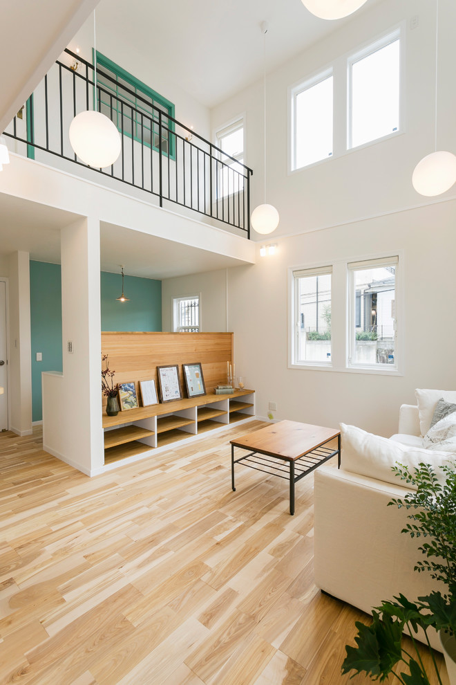 Design ideas for a scandinavian living room in Kobe with white walls, light hardwood floors and brown floor.