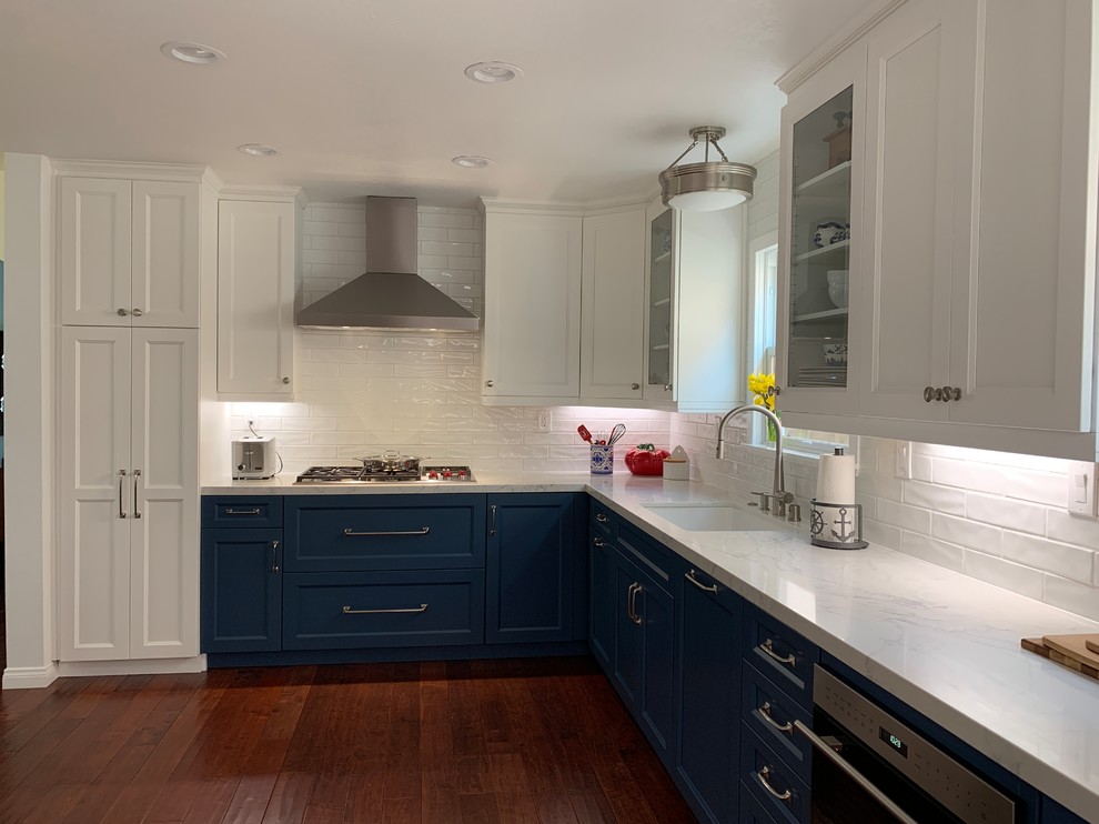 This is an example of a mid-sized transitional galley kitchen in Other with a single-bowl sink, shaker cabinets, white cabinets, quartz benchtops, white splashback, cement tile splashback, stainless steel appliances, medium hardwood floors, no island, red floor and white benchtop.