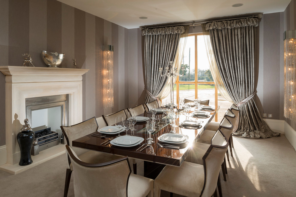 Inspiration for a mid-sized contemporary separate dining room in West Midlands with beige walls, carpet, a standard fireplace and a stone fireplace surround.