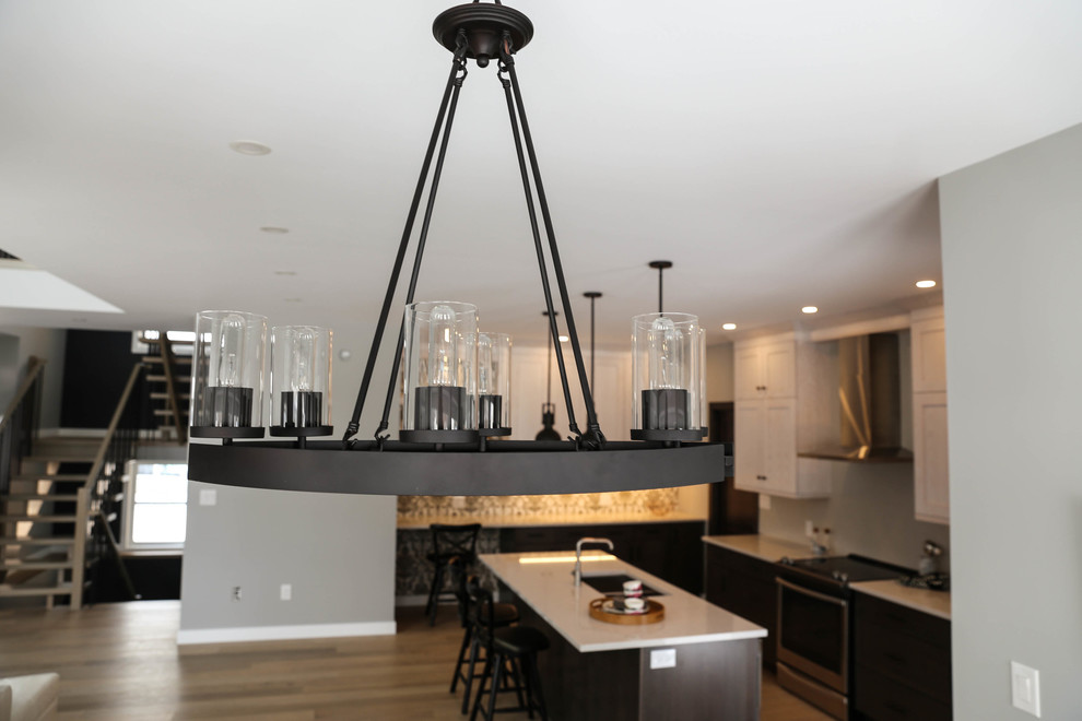 Inspiration for a mid-sized transitional galley light wood floor eat-in kitchen remodel with an undermount sink, shaker cabinets, white cabinets, marble countertops, gray backsplash, stone tile backsplash, stainless steel appliances and an island