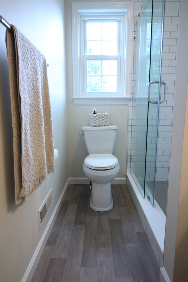This is an example of a small traditional kids bathroom in Other with shaker cabinets, white cabinets, an alcove shower, a two-piece toilet, white tile, ceramic tile, beige walls, vinyl floors, a trough sink, engineered quartz benchtops, beige floor, a sliding shower screen and beige benchtops.