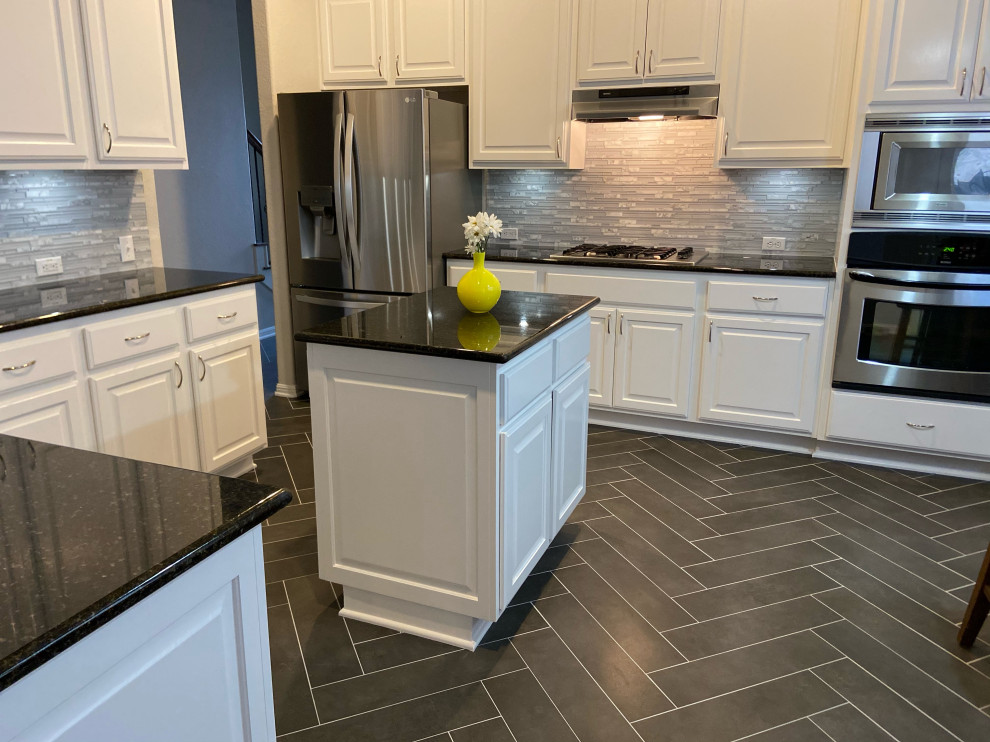 Inspiration for a transitional kitchen remodel in Austin with white cabinets and an island