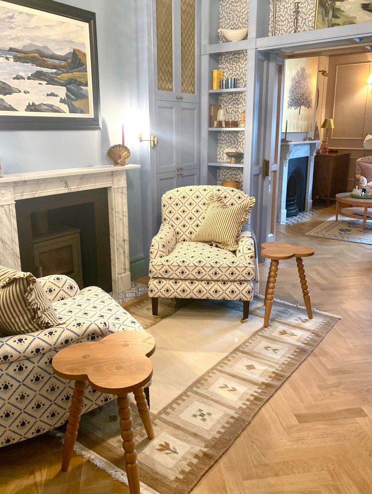Inspiration for a medium sized traditional enclosed living room in Kent with a music area, blue walls, light hardwood flooring, a standard fireplace, a stone fireplace surround, no tv, brown floors, a coffered ceiling, panelled walls and a chimney breast.