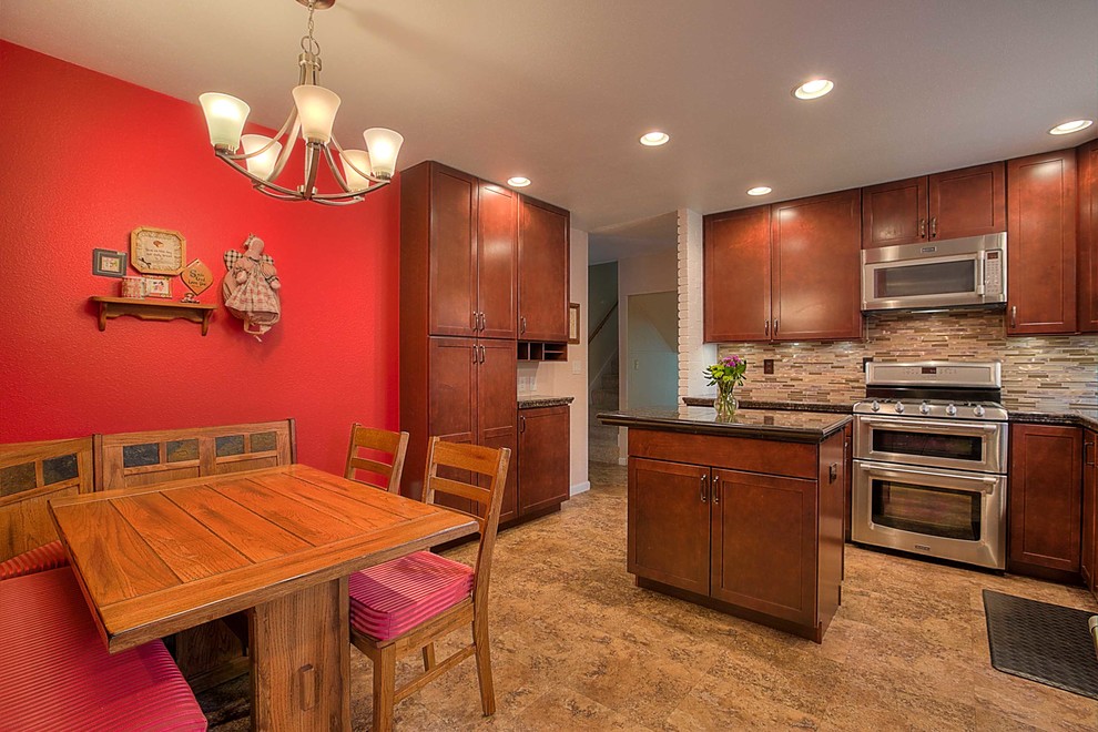 Mid-sized transitional l-shaped medium tone wood floor enclosed kitchen photo in Albuquerque with a drop-in sink, shaker cabinets, granite countertops, multicolored backsplash, glass tile backsplash, stainless steel appliances and an island