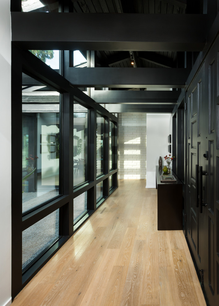 Design ideas for a large midcentury foyer in Orange County with white walls, light hardwood floors, a double front door, a black front door and beige floor.