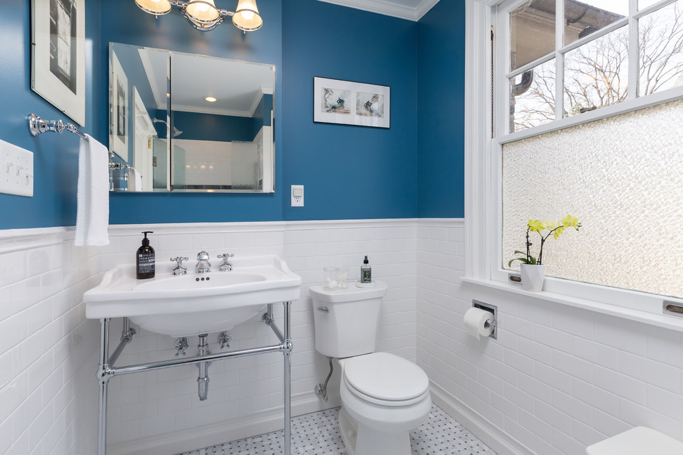 This is an example of a mid-sized traditional 3/4 bathroom in Philadelphia with white tile, subway tile, blue walls, an alcove shower, a two-piece toilet, a wall-mount sink, white floor and a hinged shower door.