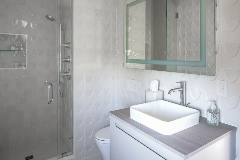 This is an example of a mid-sized beach style master wet room bathroom in New York with flat-panel cabinets, a vessel sink, a hinged shower door, a single vanity, grey cabinets, grey walls and grey benchtops.