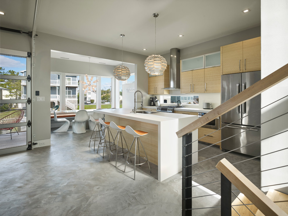 Photo of a small contemporary galley open plan kitchen in Other with an undermount sink, flat-panel cabinets, light wood cabinets, solid surface benchtops, white splashback, window splashback, stainless steel appliances, concrete floors, with island and grey floor.