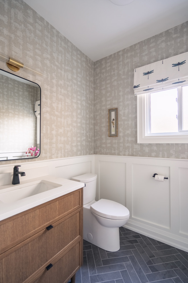 This is an example of a mid-sized traditional powder room in Toronto with medium wood cabinets, an undermount sink, engineered quartz benchtops, white benchtops and a built-in vanity.