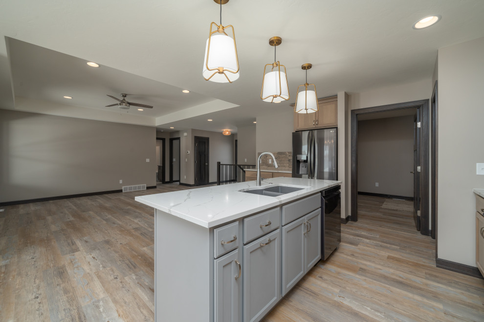 Eat-in kitchen - transitional l-shaped vinyl floor and multicolored floor eat-in kitchen idea with an undermount sink, shaker cabinets, light wood cabinets, quartz countertops, beige backsplash, black appliances, an island and white countertops
