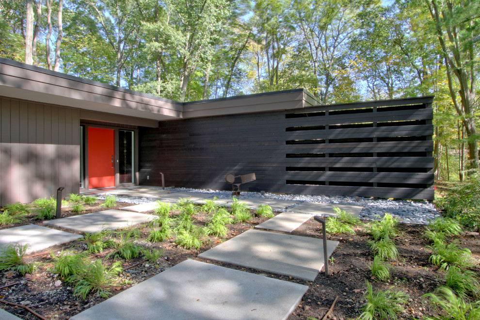Inspiration for a mid-sized midcentury one-storey brown house exterior in Indianapolis with wood siding, a flat roof and a mixed roof.