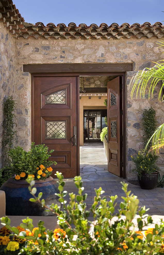 Inspiration for a mediterranean exterior in Phoenix with stone veneer.