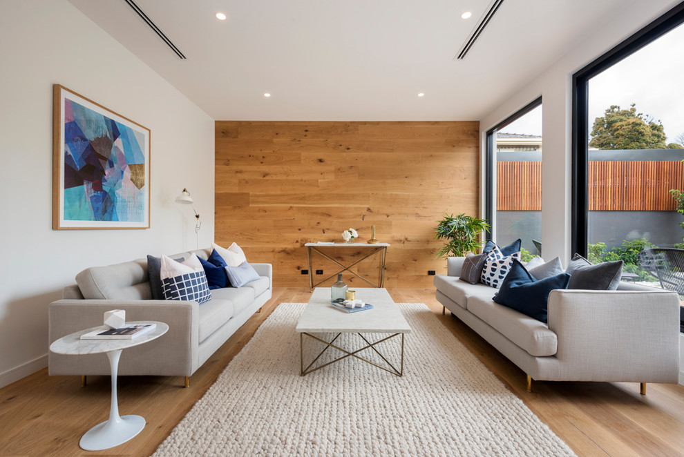 Photo of a contemporary enclosed living room in Melbourne with white walls and light hardwood floors.