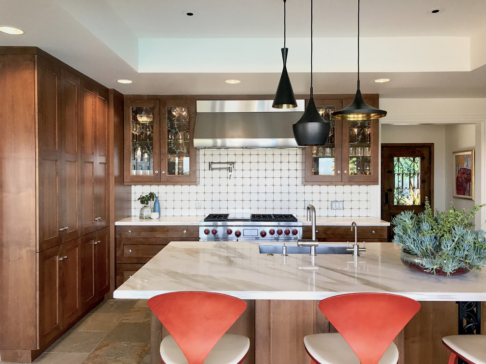 Midcentury kitchen in Los Angeles with an undermount sink, shaker cabinets, dark wood cabinets, marble benchtops, white splashback, ceramic splashback, stainless steel appliances, slate floors and with island.