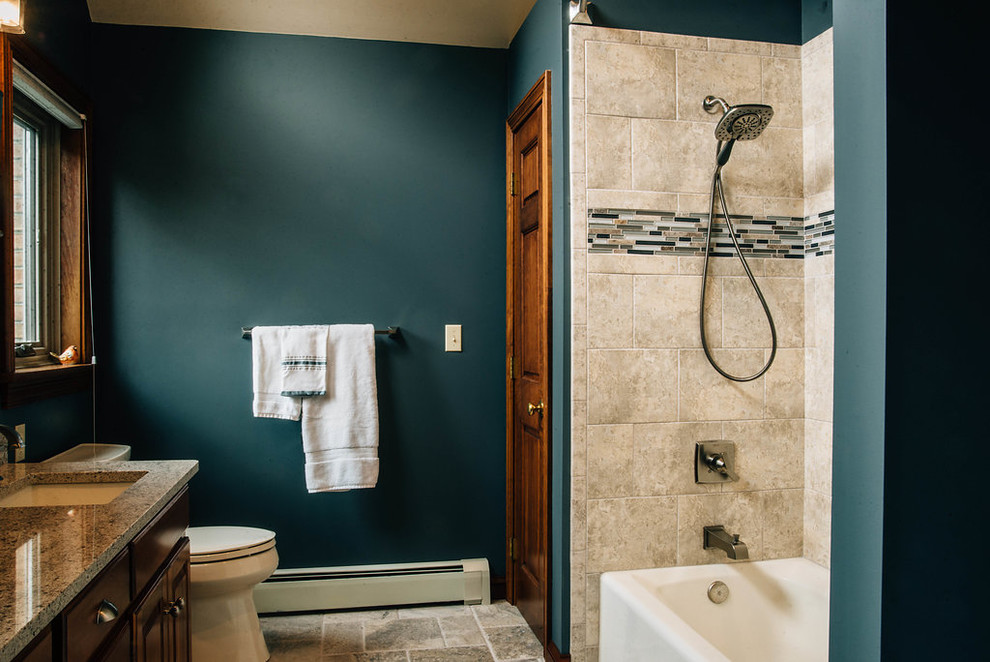 Inspiration for a mid-sized transitional master beige tile and travertine tile travertine floor and beige floor alcove bathtub remodel with raised-panel cabinets, dark wood cabinets, green walls, an undermount sink, granite countertops and gray countertops
