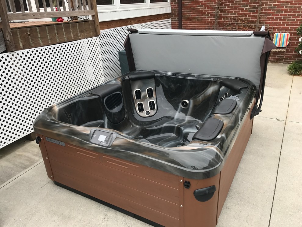 Inspiration for a mid-sized transitional backyard concrete and rectangular hot tub remodel