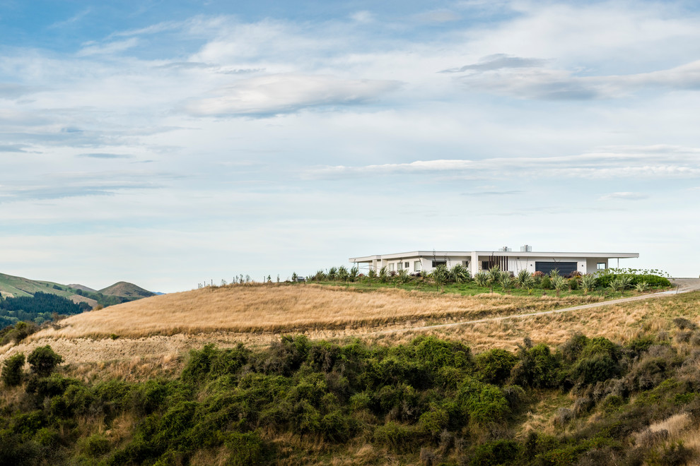 Contemporary One-storey Stucco White house exterior With a Flat Roof and a Metal Roof.