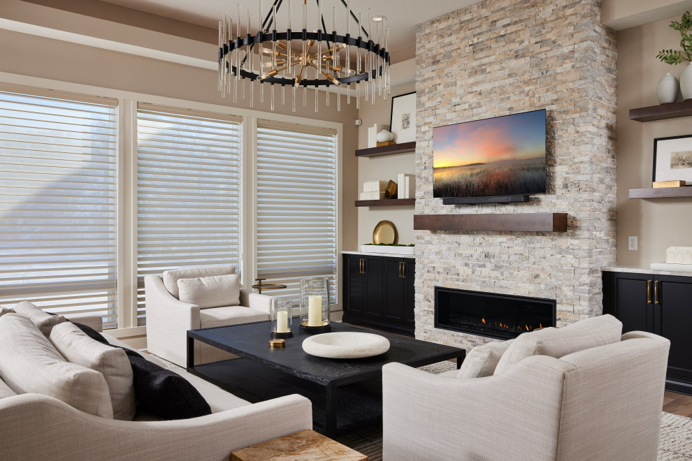На фото: большая открытая гостиная комната в современном стиле с бежевыми стенами, полом из ламината, стандартным камином, фасадом камина из кирпича, телевизором на стене и коричневым полом с