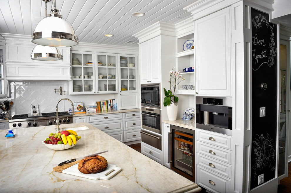 Design ideas for a large traditional eat-in kitchen in Los Angeles with white cabinets, white splashback, stainless steel appliances, dark hardwood floors, with island, an undermount sink and raised-panel cabinets.