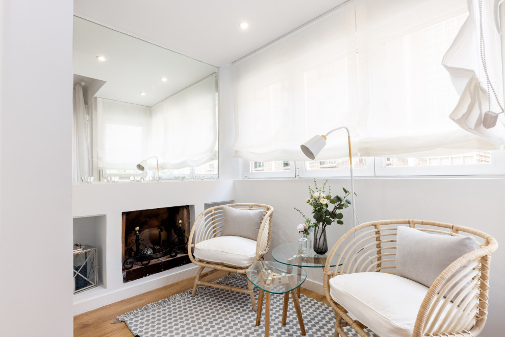 Источник вдохновения для домашнего уюта: маленькая открытая гостиная комната в современном стиле с белыми стенами, полом из ламината, стандартным камином и фасадом камина из штукатурки для на участке и в саду