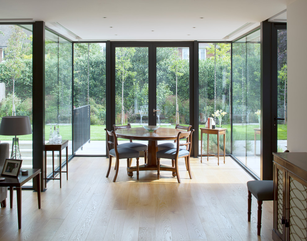 Photo of a large contemporary open plan dining in London with white walls, light hardwood floors and brown floor.