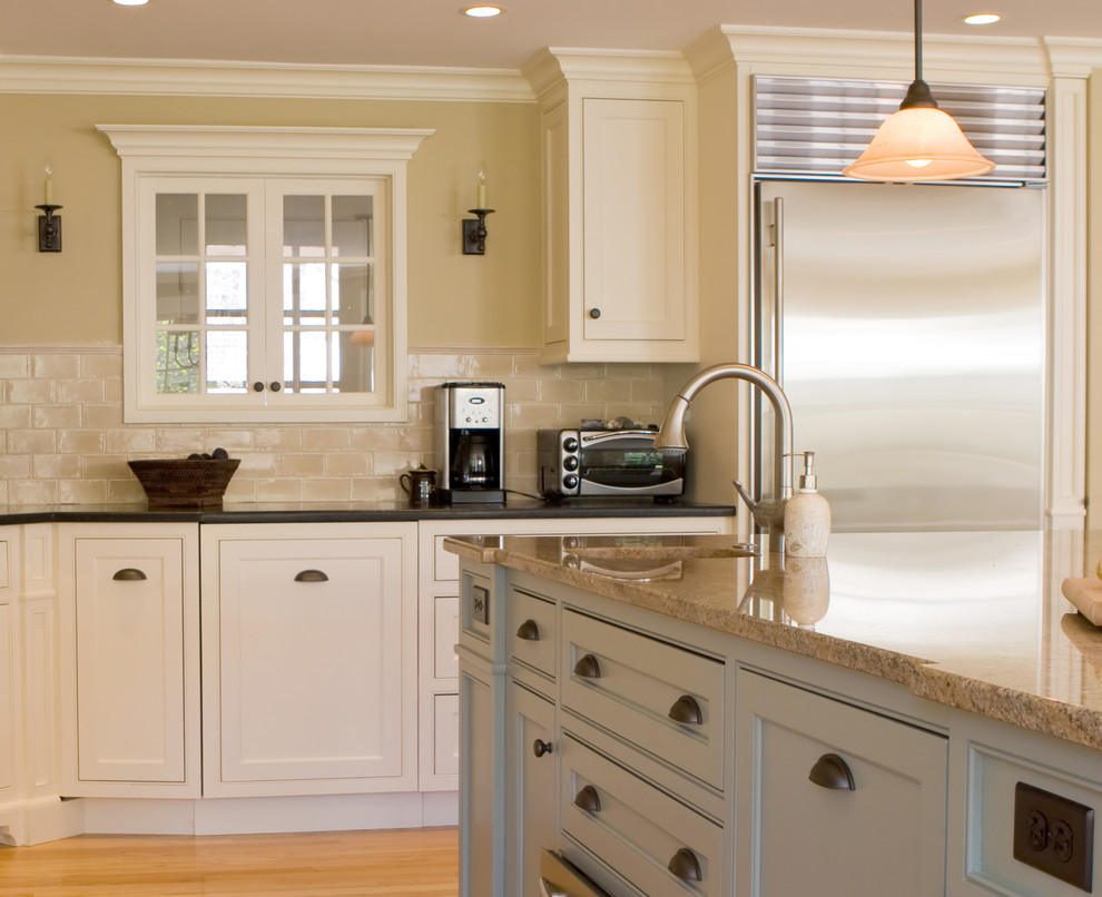 Mid-sized transitional l-shaped eat-in kitchen photo in Toronto with flat-panel cabinets, white cabinets, granite countertops, stainless steel appliances and an island