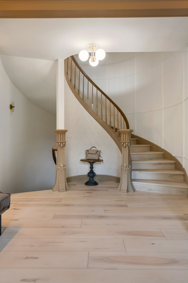 Cette photo montre un grand escalier courbe chic avec des marches en bois, des contremarches en bois, un garde-corps en bois et boiseries.