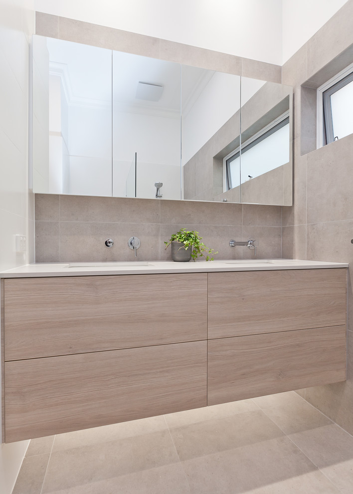Photo of a mid-sized contemporary master bathroom in Perth with light wood cabinets, a corner shower, a one-piece toilet, gray tile, porcelain tile, white walls, porcelain floors, an undermount sink, engineered quartz benchtops, grey floor, a hinged shower door and white benchtops.