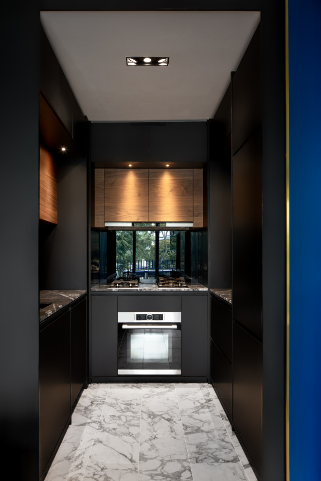 This is an example of a small contemporary u-shaped separate kitchen in Singapore with an undermount sink, flat-panel cabinets, black cabinets, mirror splashback, panelled appliances, no island, grey floor and grey benchtop.