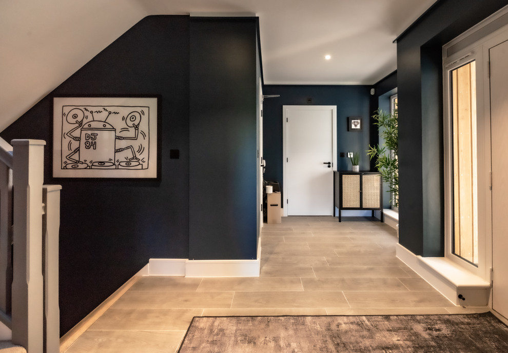 Inspiration for a medium sized urban foyer in Kent with blue walls, laminate floors, a single front door, a white front door, grey floors and feature lighting.