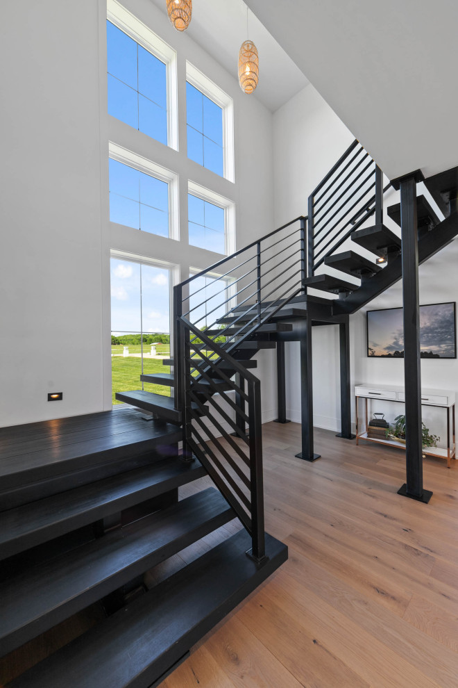 Modelo de escalera en U de estilo de casa de campo grande con escalones de madera, contrahuellas de metal y barandilla de metal