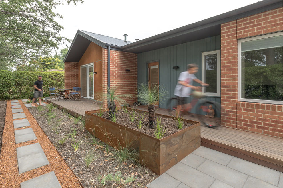 Inspiration for a small contemporary one-storey brick multi-coloured house exterior in Canberra - Queanbeyan with a flat roof and a metal roof.