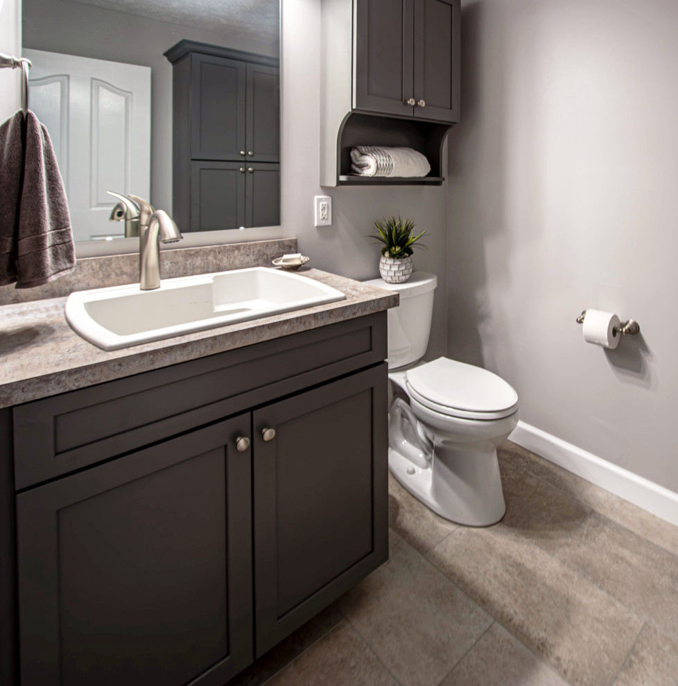 Small traditional cloakroom in Cleveland with flat-panel cabinets, grey cabinets, a two-piece toilet, grey walls, wood-effect flooring, a built-in sink, laminate worktops, beige floors, beige worktops and a built in vanity unit.