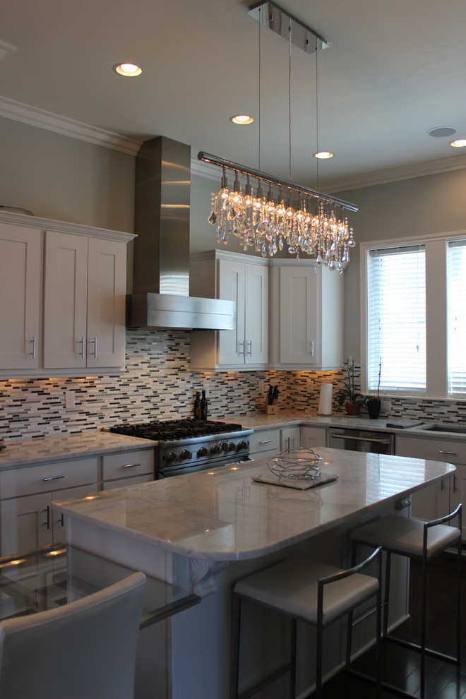 Open concept kitchen - mid-sized transitional u-shaped dark wood floor open concept kitchen idea in Cedar Rapids with a single-bowl sink, shaker cabinets, white cabinets, marble countertops, multicolored backsplash, stainless steel appliances, gray walls and an island