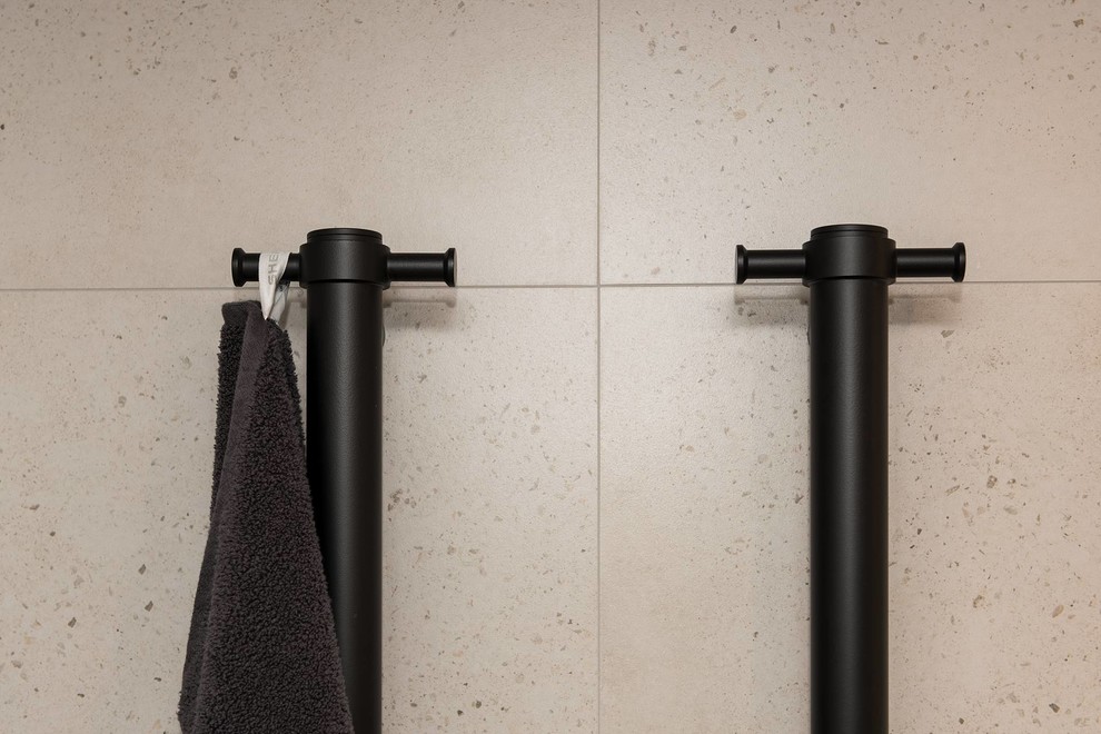 This is an example of a large industrial master bathroom in Sydney with flat-panel cabinets, white cabinets, an open shower, a one-piece toilet, stone slab, porcelain floors, a vessel sink, an open shower, beige tile, beige walls, engineered quartz benchtops, brown floor, beige benchtops, a niche and a double vanity.