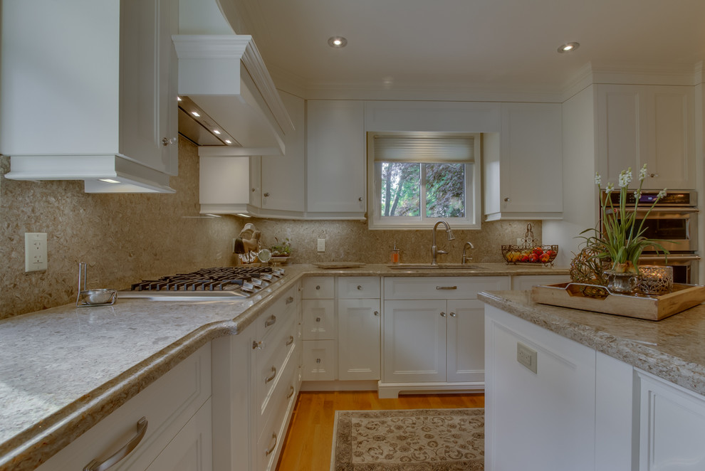 Example of a mid-sized transitional l-shaped medium tone wood floor eat-in kitchen design in Toronto with an undermount sink, shaker cabinets, white cabinets, quartzite countertops, brown backsplash, stone slab backsplash, stainless steel appliances and an island