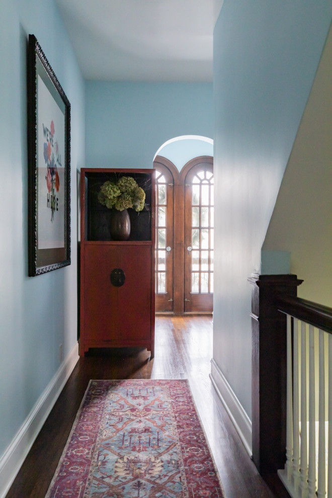 Exemple d'une entrée éclectique avec un mur bleu, parquet foncé, une porte double, une porte en bois brun et un sol marron.
