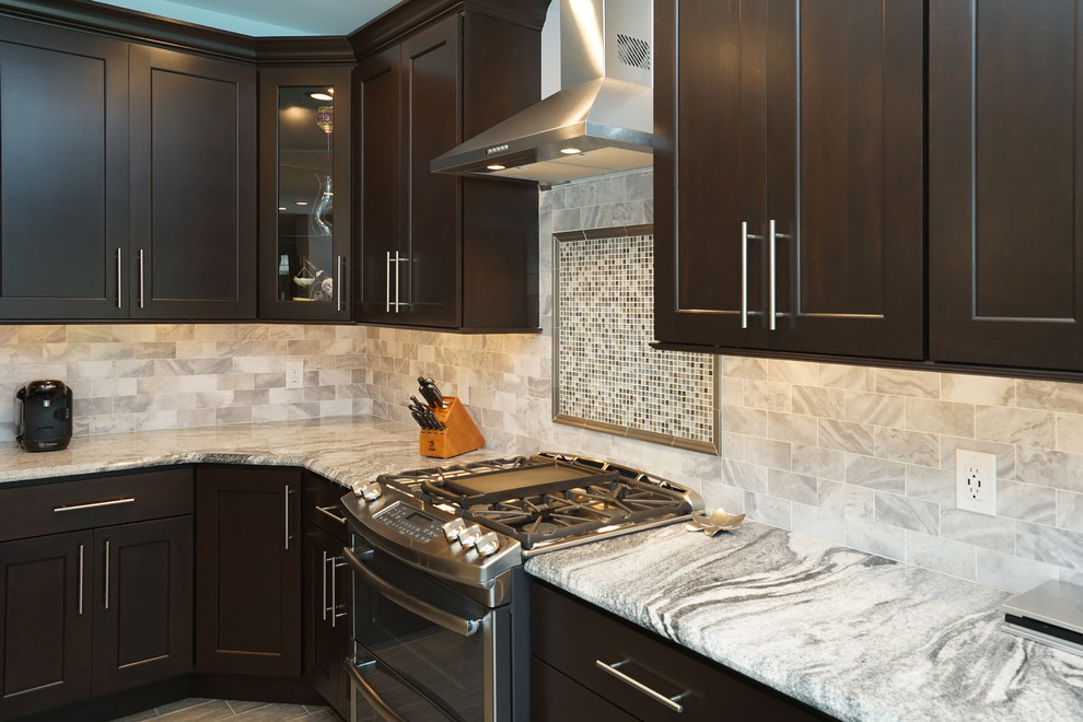 Large transitional l-shaped vinyl floor and brown floor eat-in kitchen photo in Philadelphia with a double-bowl sink, granite countertops, gray backsplash, stone tile backsplash, stainless steel appliances, an island, shaker cabinets and dark wood cabinets