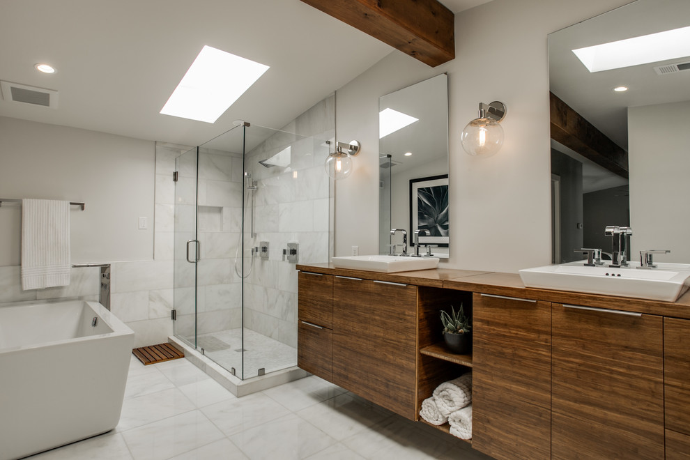 Midcentury bathroom in Dallas with a vessel sink, flat-panel cabinets, dark wood cabinets, a freestanding tub, a corner shower, white tile and grey walls.