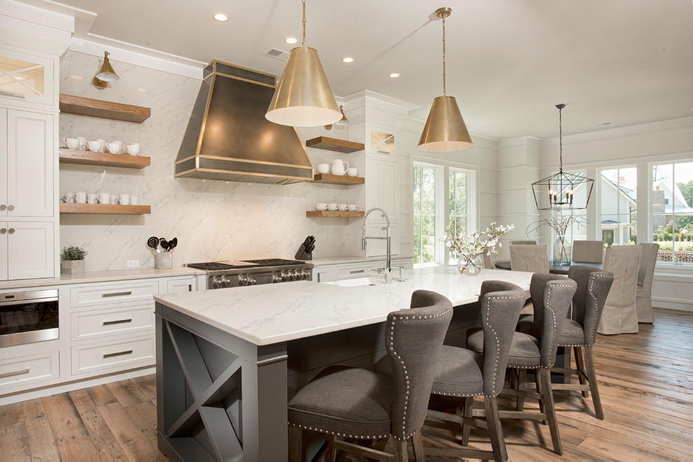 Design ideas for a country galley eat-in kitchen in Other with an undermount sink, shaker cabinets, white cabinets, white splashback, stainless steel appliances, medium hardwood floors, with island, brown floor and white benchtop.