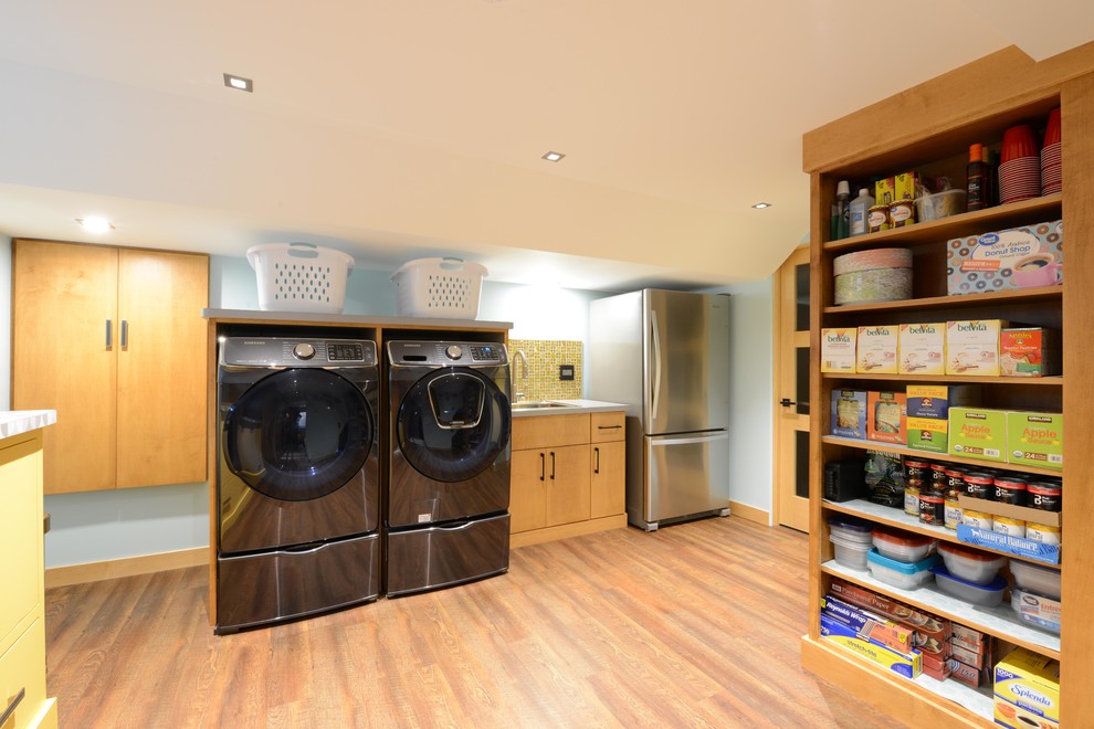 Small midcentury utility room in Other with beige walls, medium hardwood floors, beige floor, a drop-in sink, flat-panel cabinets, light wood cabinets, quartzite benchtops, a side-by-side washer and dryer and grey benchtop.